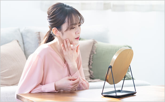 憂鬱な表情で鏡を見る女性