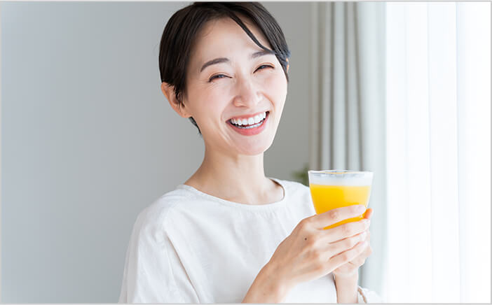 野菜ジュースを飲む笑顔の女性
